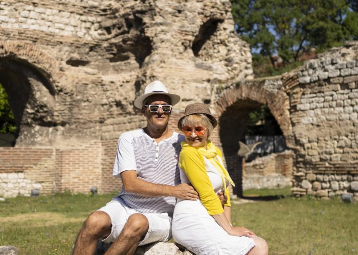 full-shot-senior-couple-sitting-rock